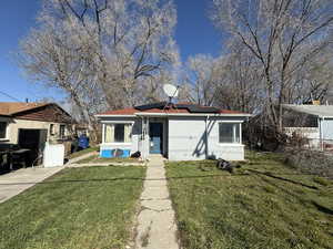 View of front facade with a front lawn and roof mounted solar panels