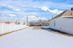 Yard covered in snow with a mountain view