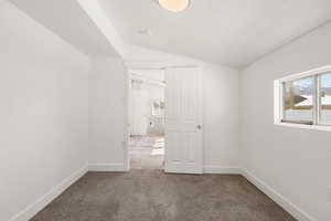 Unfurnished room with dark colored carpet and baseboards