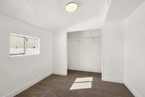 Unfurnished bedroom with dark carpet and a closet