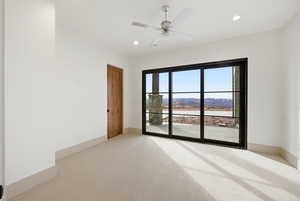Spare room featuring light colored carpet, ceiling fan, and recessed lighting
