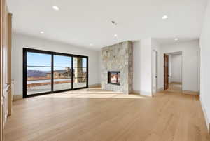 Unfurnished living room with light wood-style floors, a fireplace, and recessed lighting
