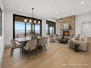 Dining space with a chandelier, light wood-type flooring, and a fireplace