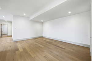 Empty room featuring light wood-type flooring and recessed lighting