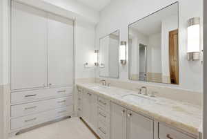 Bathroom featuring double vanity and light tile patterned floors
