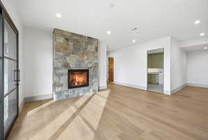 Unfurnished living room featuring light wood finished floors, a fireplace, and recessed lighting