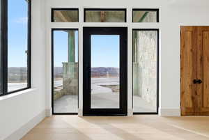 Doorway with wood finished floors and baseboards