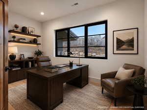 Office area with light wood-style floors and recessed lighting