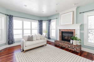 Living room featuring dark wood-type flooring and a fireplace