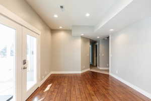 Spare room with hardwood / wood-style floors, recessed lighting, and french doors