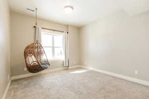 Carpeted spare room featuring baseboards