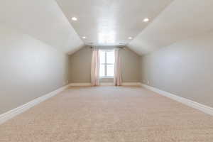 Additional living space with light colored carpet and recessed lighting