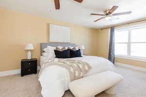 Bedroom with light carpet and a ceiling fan