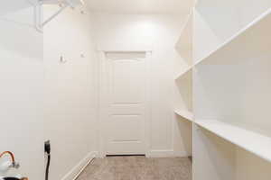 Walk in closet featuring light carpet