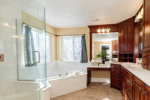 Bathroom featuring a stall shower, vanity, a bath, and light tile patterned flooring