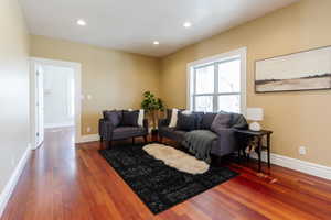 Living area featuring dark wood finished floors and recessed lighting