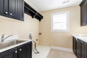 Laundry area with cabinet space, washer hookup, light carpet, and electric dryer hookup