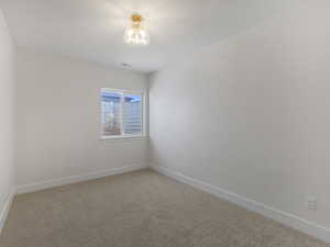 Spare room featuring carpet floors and baseboards