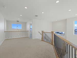 Hallway featuring light carpet, recessed lighting, and an upstairs landing