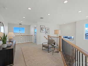 Hall with light colored carpet, healthy amount of natural light, and recessed lighting