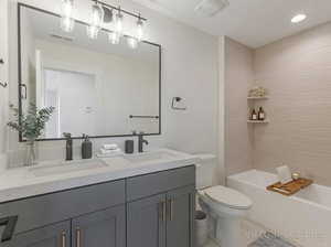Full bathroom with double vanity and bathing tub / shower combination