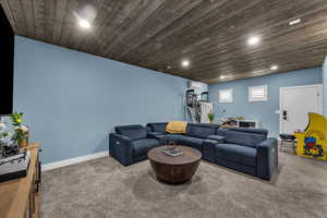 Living room featuring carpet flooring, wooden ceiling, and recessed lighting