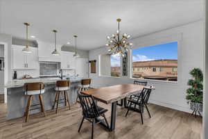 Dining space with suspended lighting and light wood finished floors