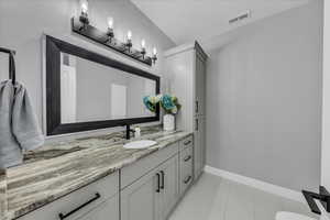 Full bath with vanity and baseboards