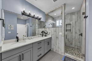 Bathroom featuring double vanity and a shower stall