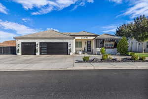 View of front of house with a porch, a garage, concrete driveway, stone siding, and stucco siding