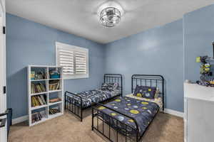 Bedroom featuring light colored carpet and baseboards