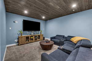 Living room with carpet floors, wooden ceiling, and recessed lighting