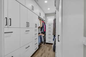 Walk in closet with light wood-style flooring