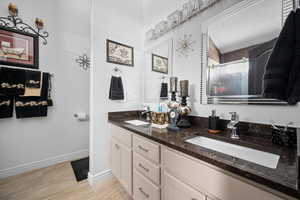 Bathroom featuring a shower stall and double vanity