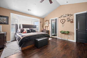 Bedroom featuring wood finished floors, lofted ceiling, a ceiling fan, and ensuite bath