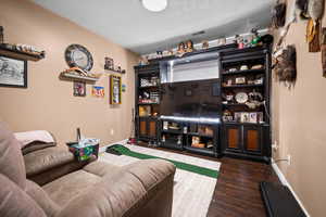 Living area featuring dark wood-type flooring and baseboards