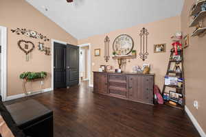 Living area featuring lofted ceiling and dark wood-style floors