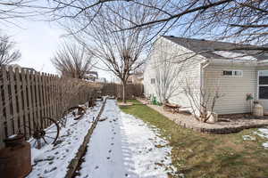 View of snowy exterior featuring a fenced backyard
