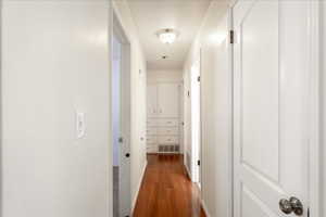 Hall featuring dark wood-style flooring and baseboards