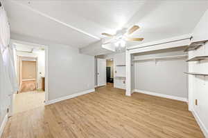 Unfurnished bedroom featuring light wood-style flooring, ceiling fan, and a closet