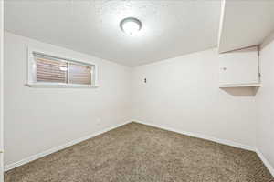 Unfurnished room with a textured ceiling and carpet floors