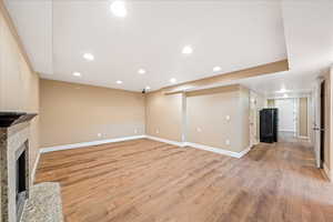 Unfurnished living room with light wood-type flooring, recessed lighting, and a fireplace