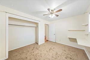 Unfurnished bedroom featuring carpet floors, a ceiling fan, and a closet