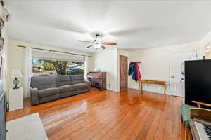 Living area featuring light wood finished floors and ceiling fan
