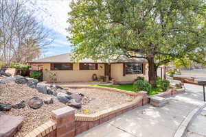 Single story home featuring brick siding, a patio, and roof with shingles