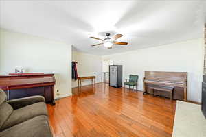 Living area featuring light wood-style floors and ceiling fan