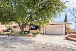 View of front of house with concrete driveway, a garage, roof with shingles, and brick siding