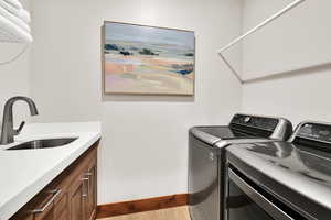 Laundry area with a sink and washing machine and dryer