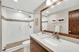 Full bath with vanity, a shower stall, recessed lighting, and a baseboard heating unit