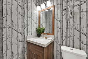 Bathroom with wallpapered walls and vanity